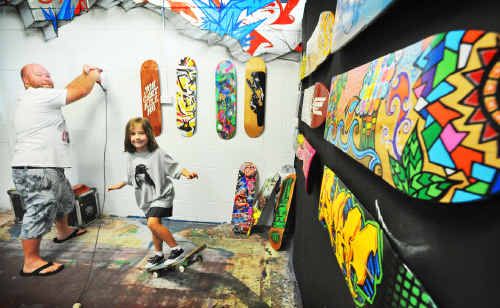 Mikaela Johnston gets in the sk8 mood while dad Ashley hangs skate decks for the Board Writers exhibition, on show at Open Studio, Wednesday-Saturday, until April 14. Mikaela Johnston gets in the sk8 mood while dad Ashley hangs skate decks for the Board Writers exhibition, on show at Open Studio, Wednesday-Saturday, until April 14.